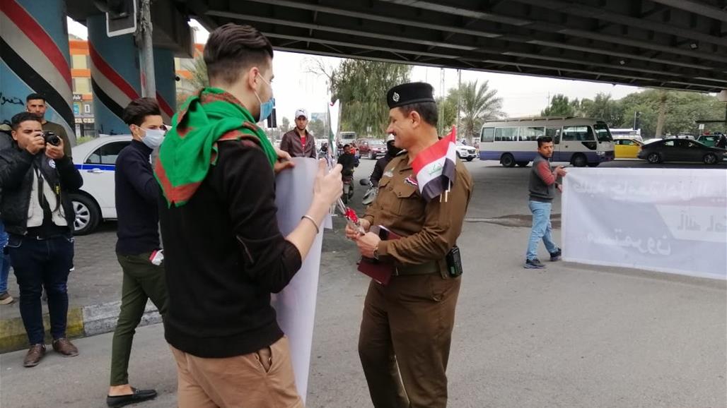 بالصور.. القوات الامنية في كربلاء تهدي الطلبة المتظاهرين الورود والاعلام العراقية 