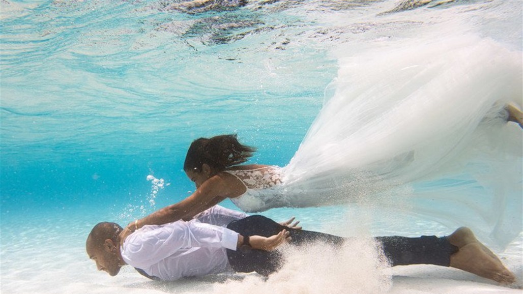 رجل وزوجته يحتفلان بزفافهما تحت الماء (صور)
