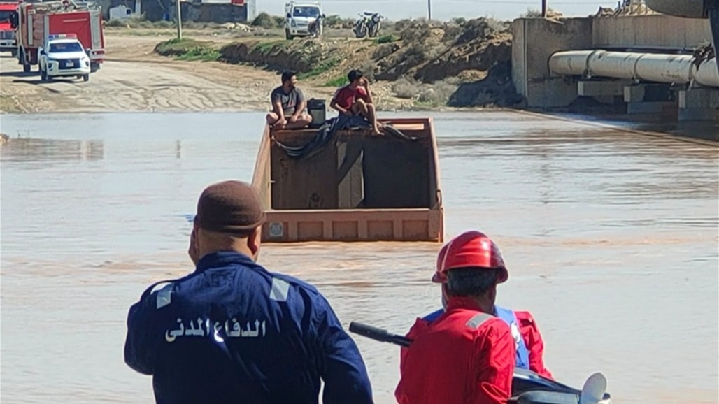 واسط.. إنقاذ شخصين من شاحنة حمل غرقت بمياه السيول (صور) 