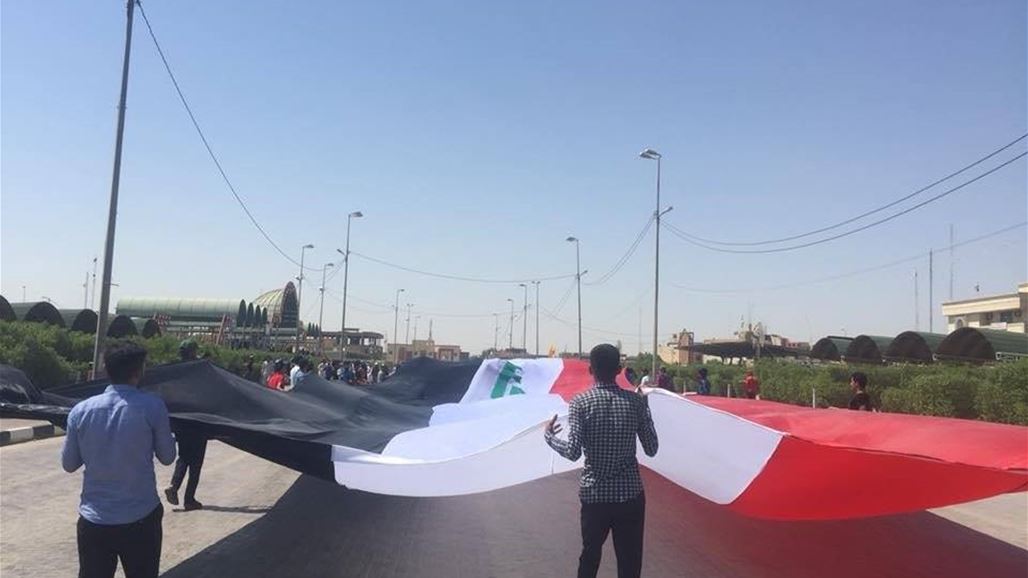 بالصور.. متظاهرو المثنى يرفعون أطول علم عراقي